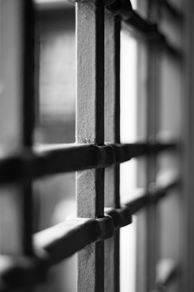 black and white close-up photo of prison bars