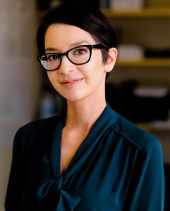 Photograph of Ana, a woman with dark hair and glasses,